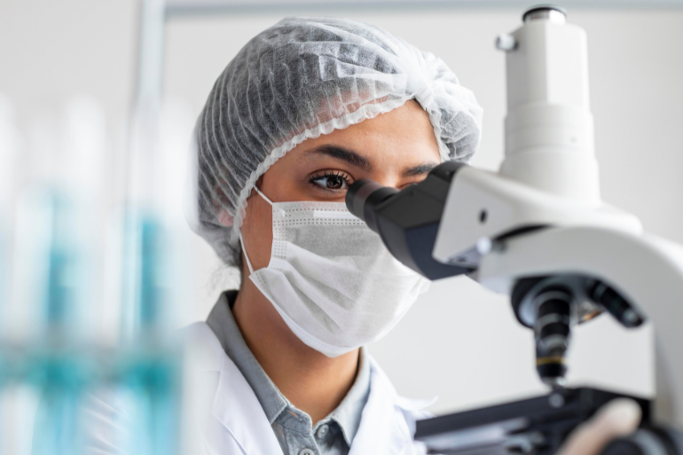 a woman using microscope in the lab